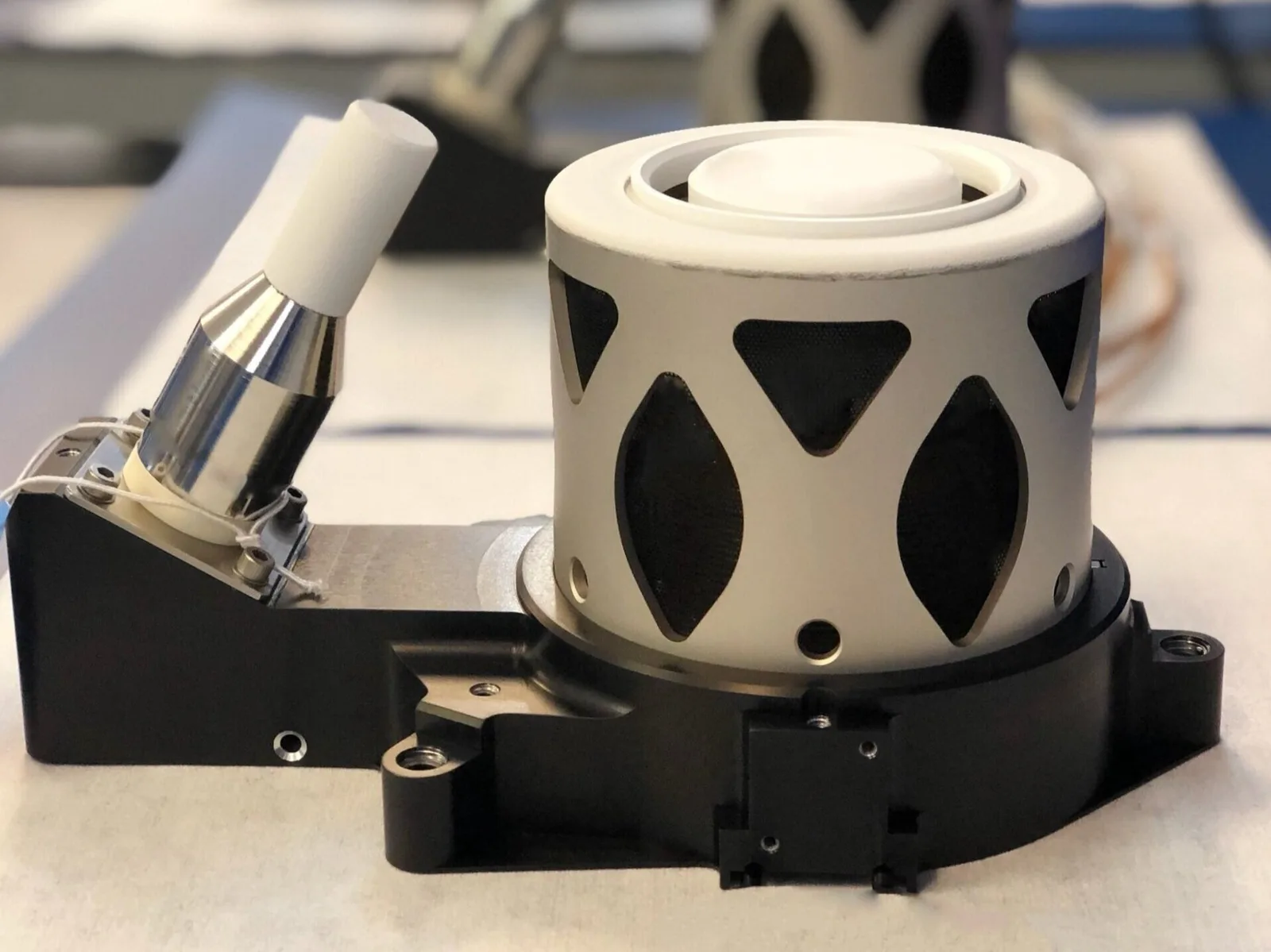 Busek BHT-350 Hall thruster, a white cylindrical thruster body with its cathode mounted alongside on a black bracket