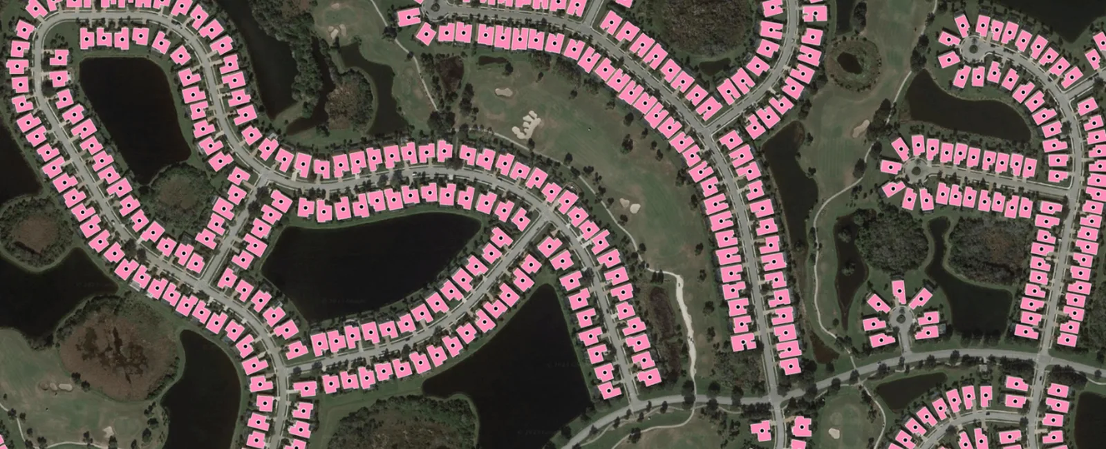 Aerial image of a suburban neighborhood with each house footprint highlighted in pink, as used for building-based geocoding