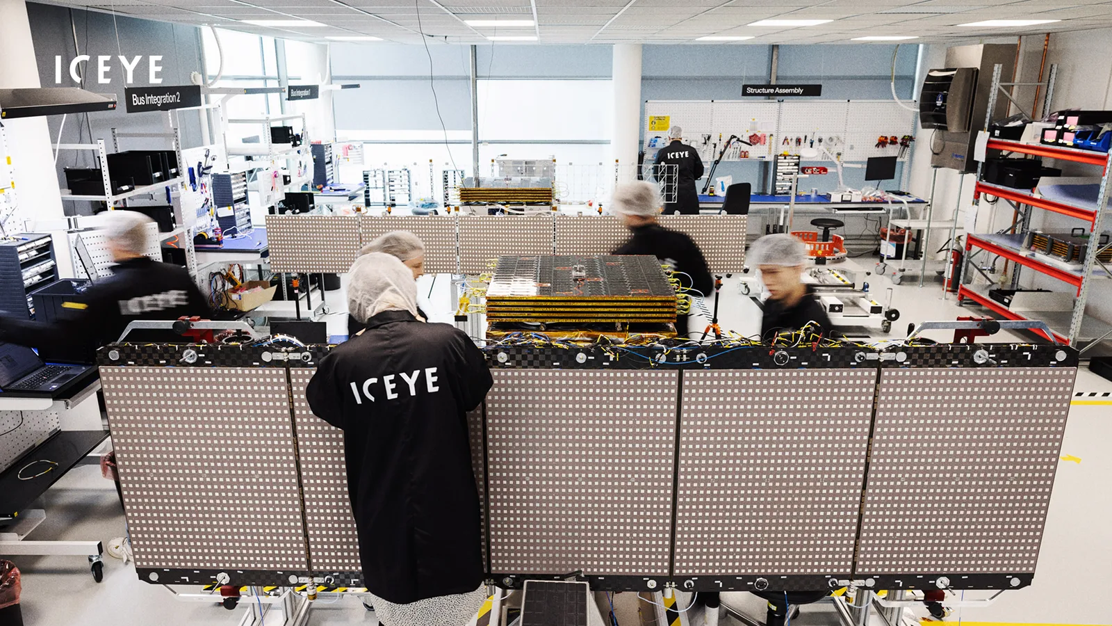 ICEYE engineers integrating a radar satellite with its large flat antenna panels unfolded in the company's factory