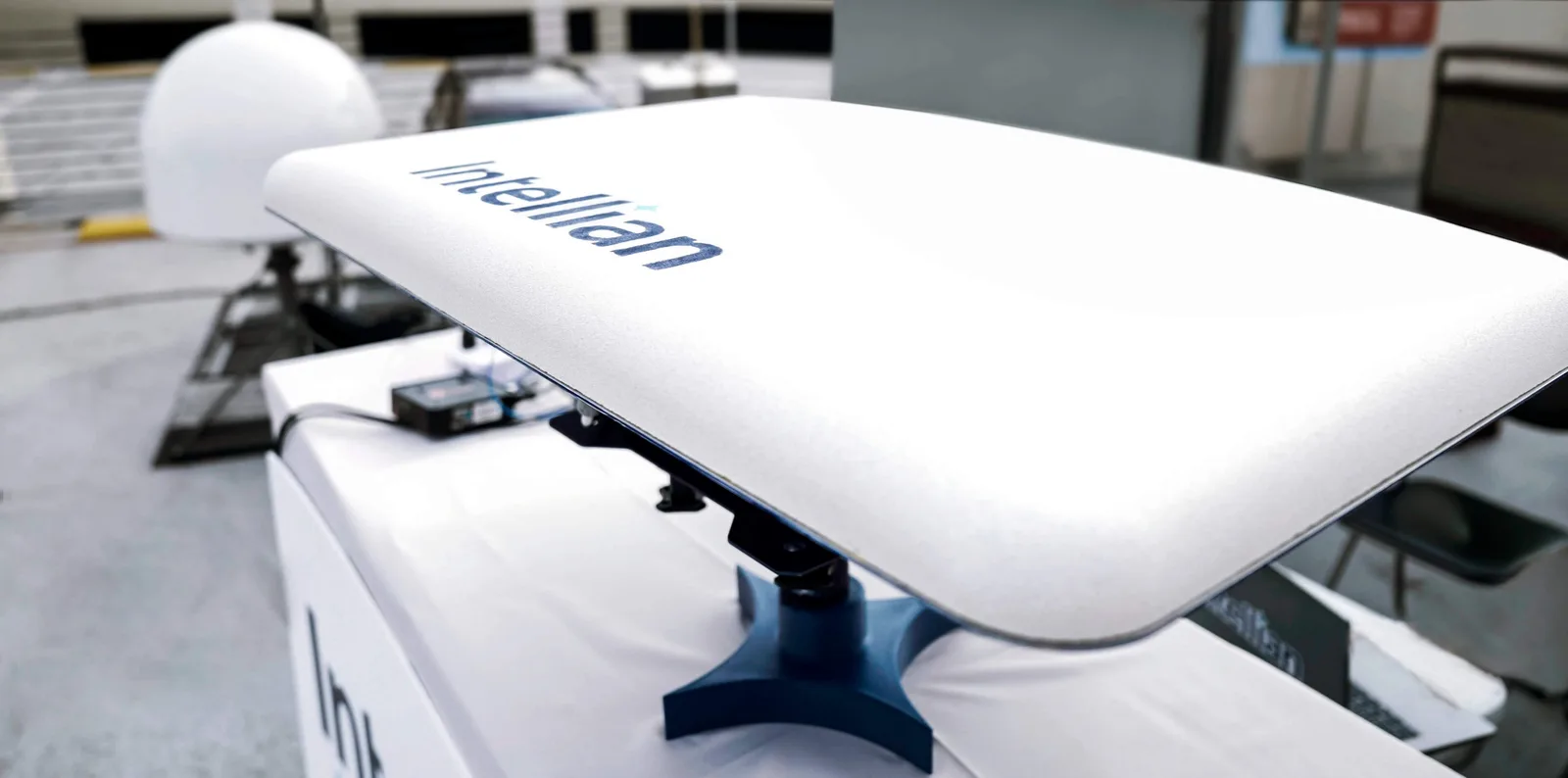 White Intellian flat-panel user terminal for the OneWeb low Earth orbit network mounted on a tilted stand