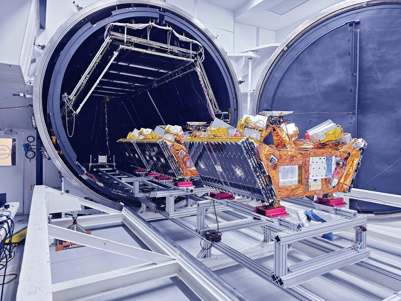 Kepler satellites on a test rack being moved into a thermal vacuum chamber