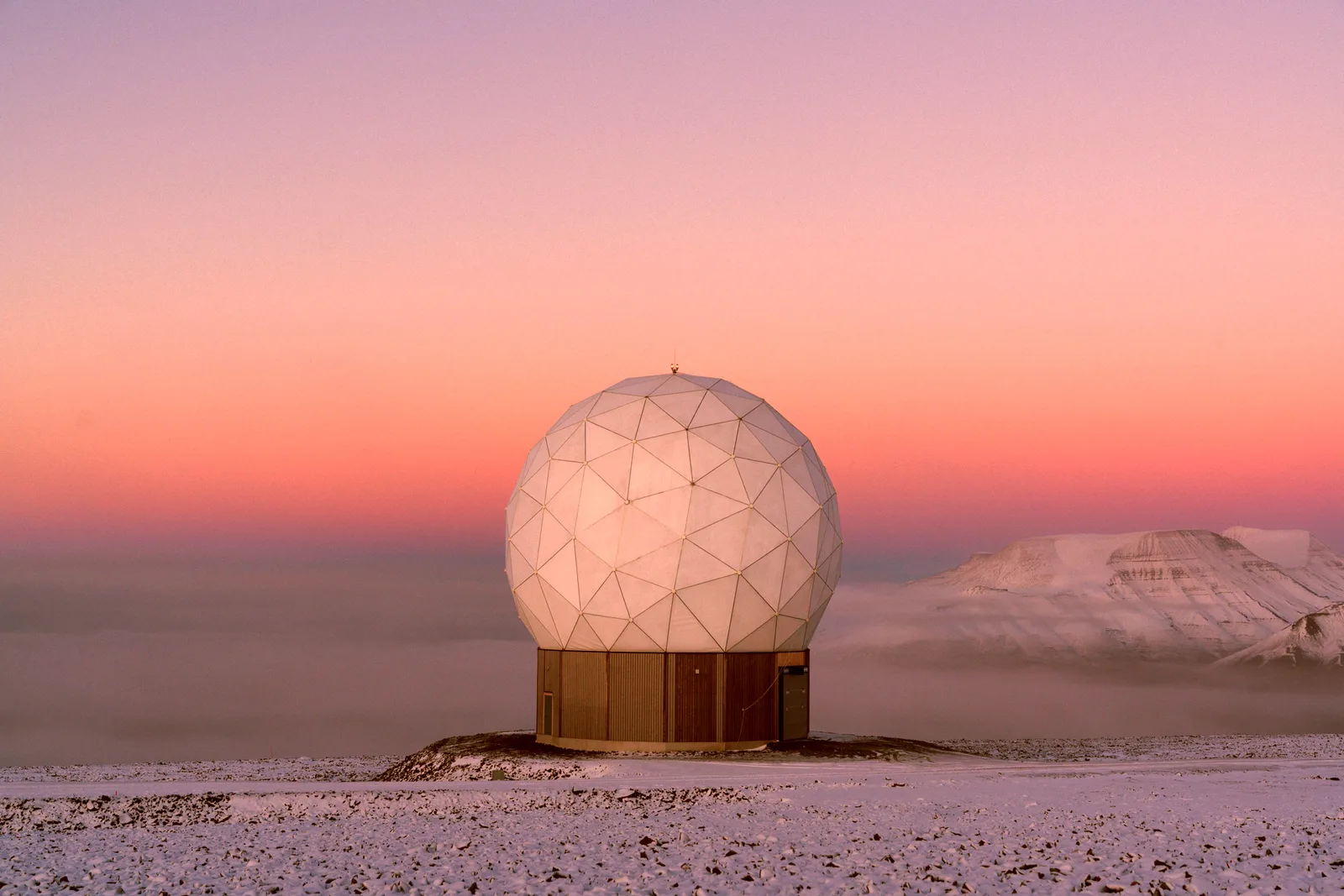 KSATlite ground station antenna radome on a snowy plateau at sunset