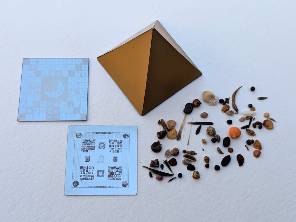 LifeShip's gold pyramid archive beside seeds and two etched archive discs before flight to the Moon