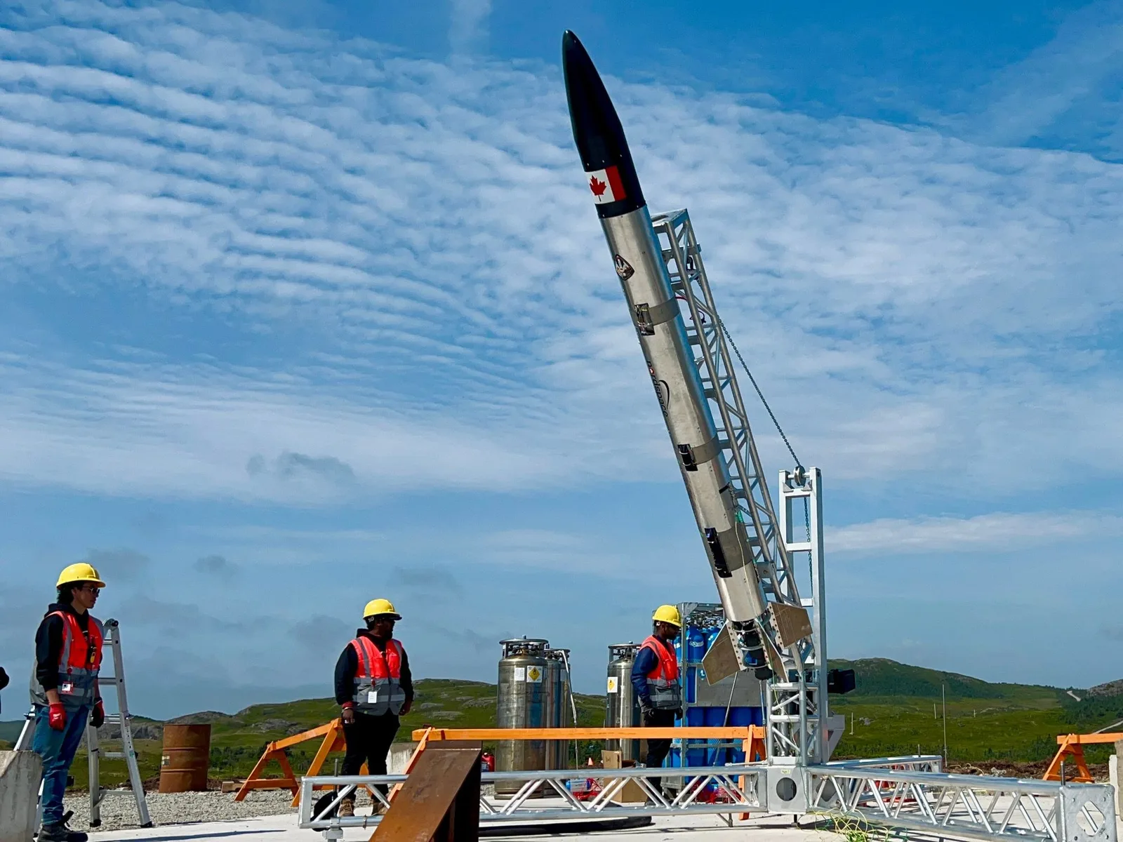 NordSpace Taiga suborbital rocket raised on its launch rail with crew members at the pad