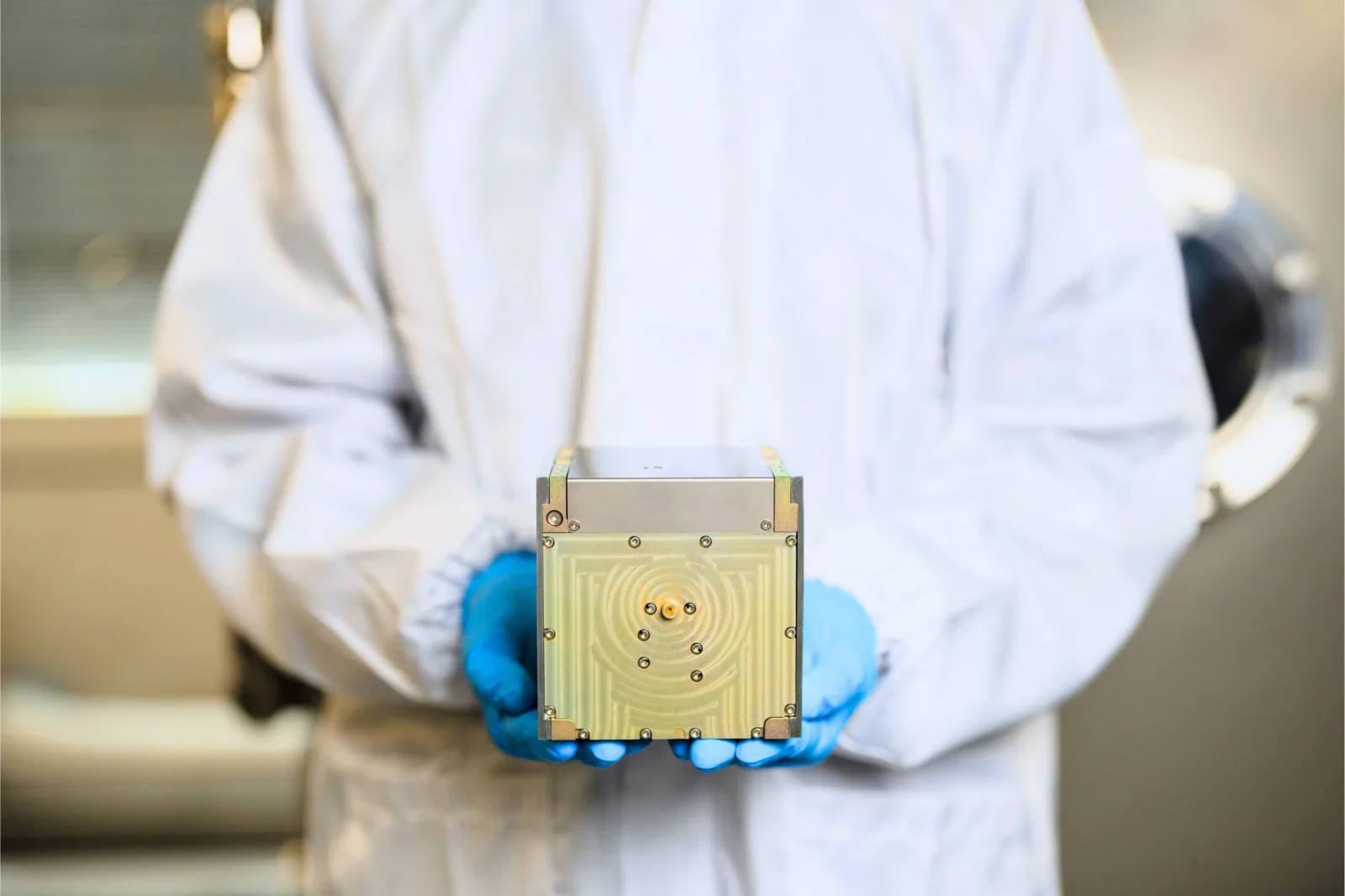 Gloved hands holding a Pale Blue PBR-20 water resistojet thruster unit