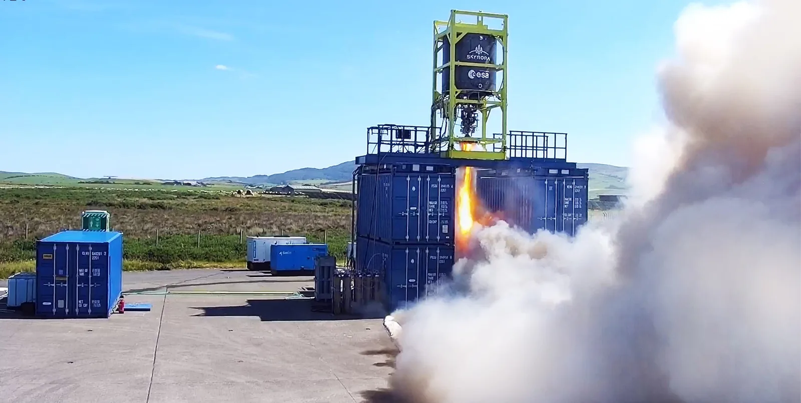 The Skyrora XL second stage firing its 70 kN engine on a test stand at Machrihanish, with exhaust billowing to the side