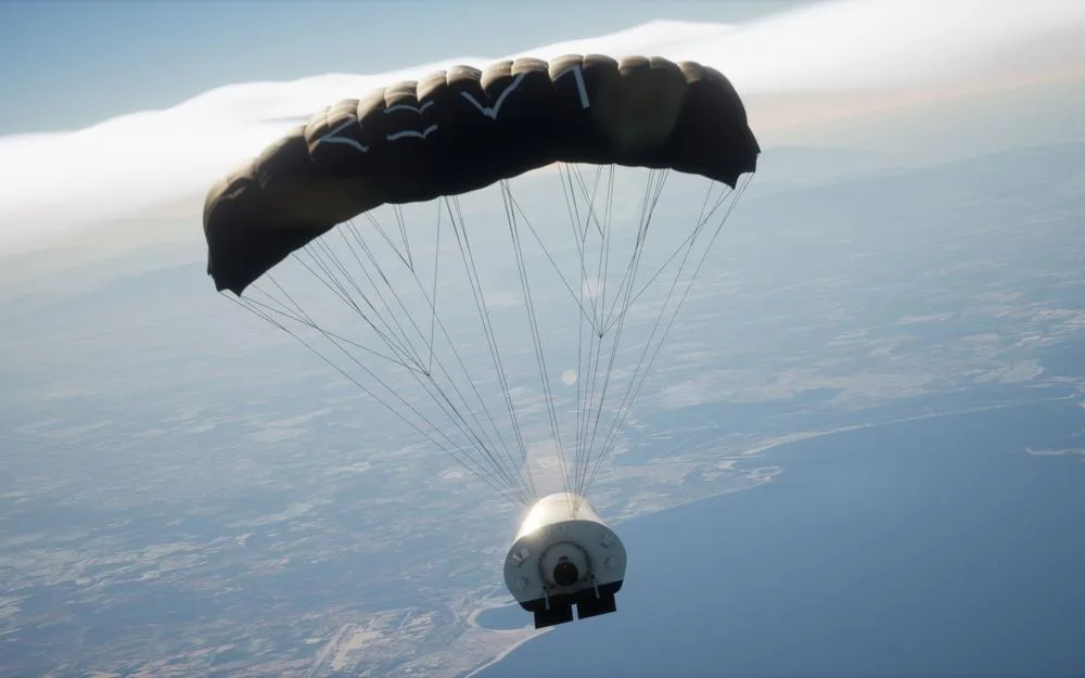 Rendering of the REV1 cargo spacecraft descending under a large parafoil over a coastline