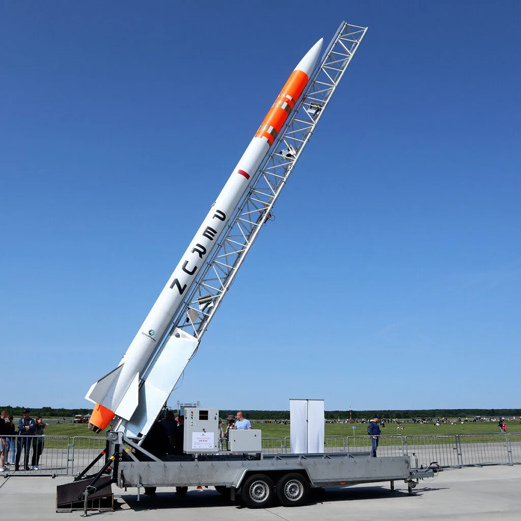 SpaceForest's white and orange PERUN suborbital rocket raised on its mobile launch rail