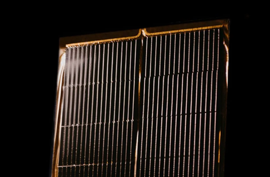 Close-up of a Starpath Starlight space solar panel, showing rows of thin solar cell strips in a gold frame against a dark background