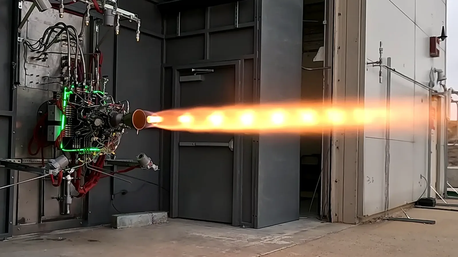 Ursa Major's Draper liquid rocket engine firing horizontally on a test stand during a hotfire test