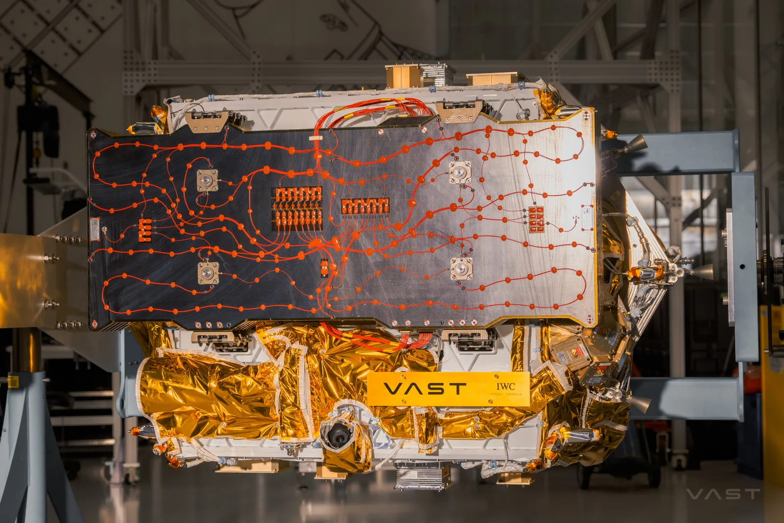 The Haven Demo satellite in a cleanroom before launch, showing its solar array panel and gold thermal blanketing